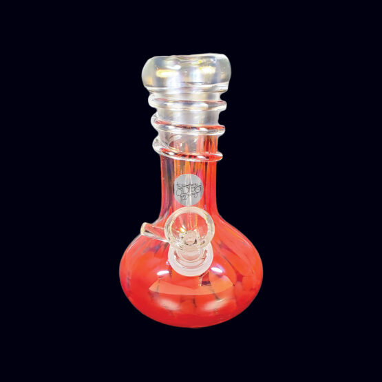A red glass pipe sitting on top of a table.