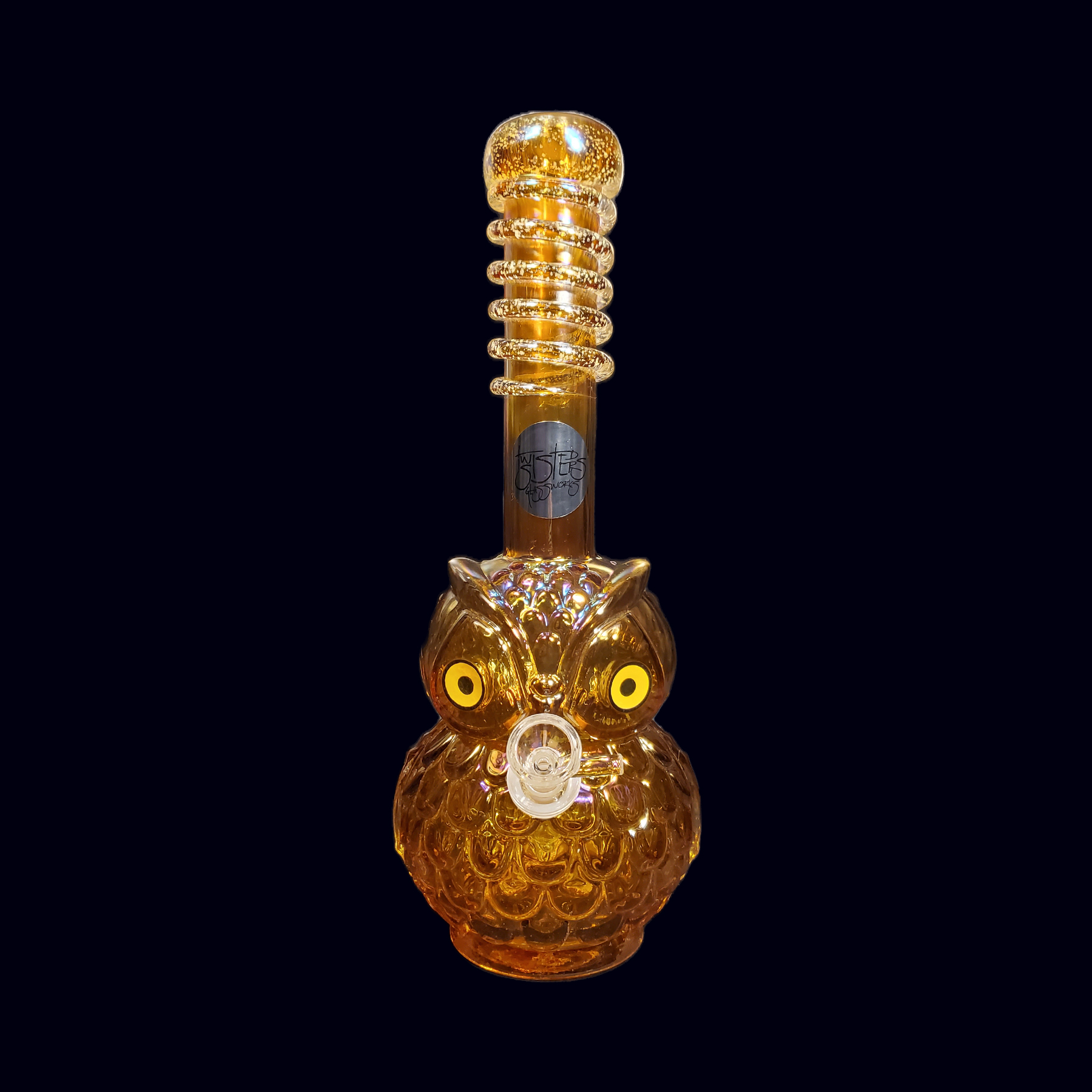 A glass owl bottle with yellow eyes.
